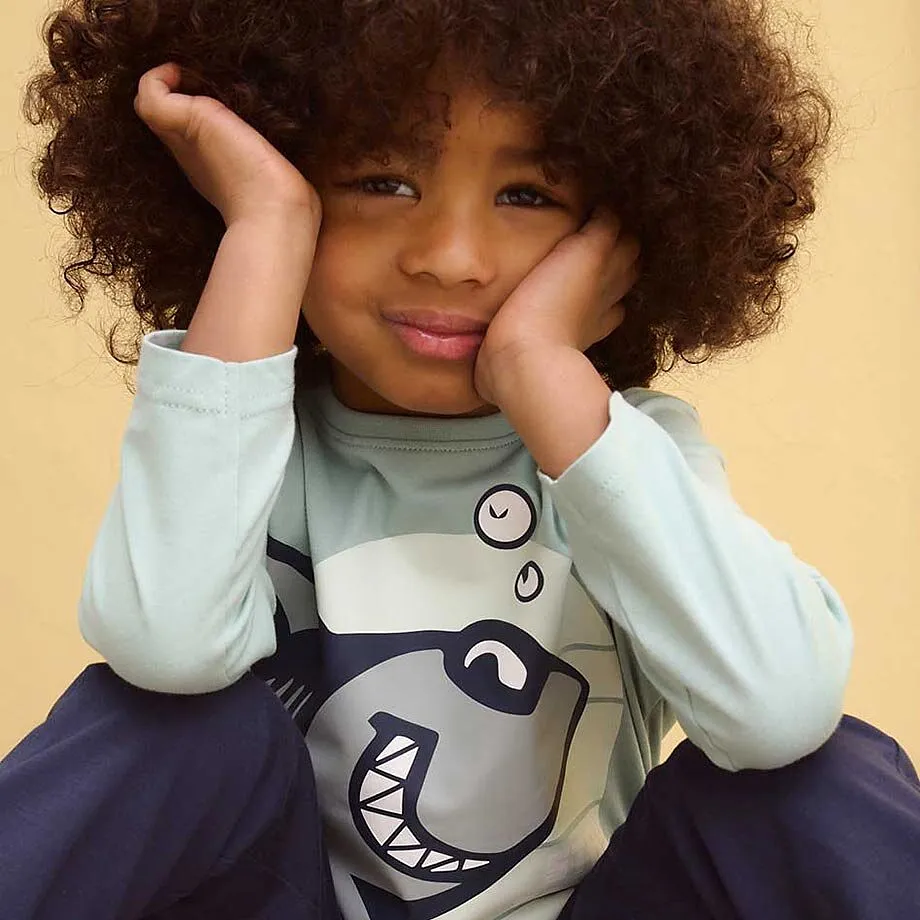 Maglia con squalo, abbinato a pantaloni scuri.