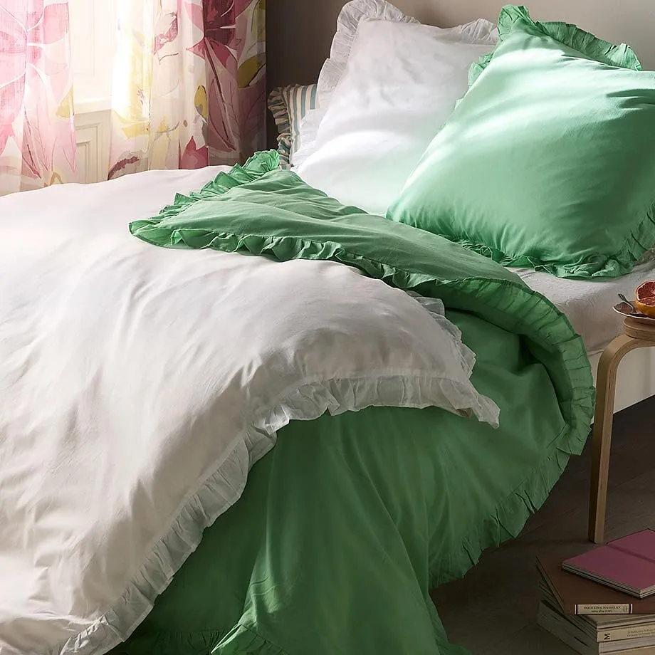 Lenzuola bianche e verdi adornano il comodo letto.