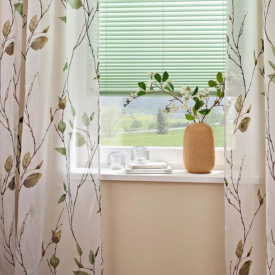 Tende con motivi floreali decorano la finestra.