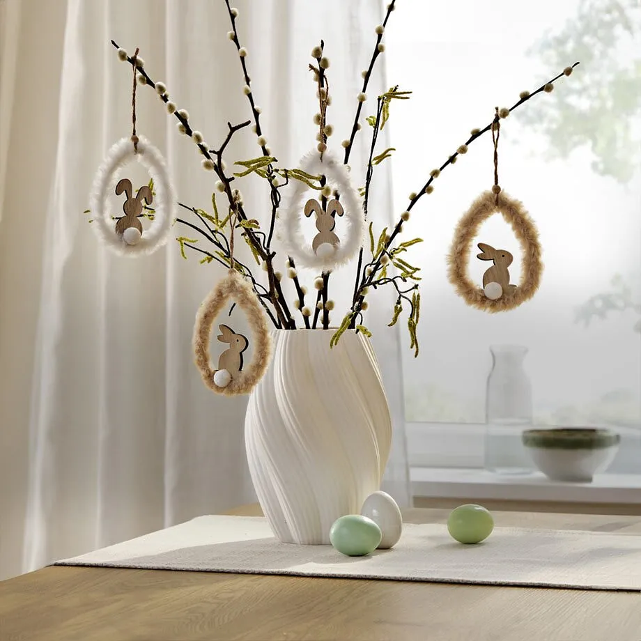 Decorazione pasquale con rami in vaso bianco.