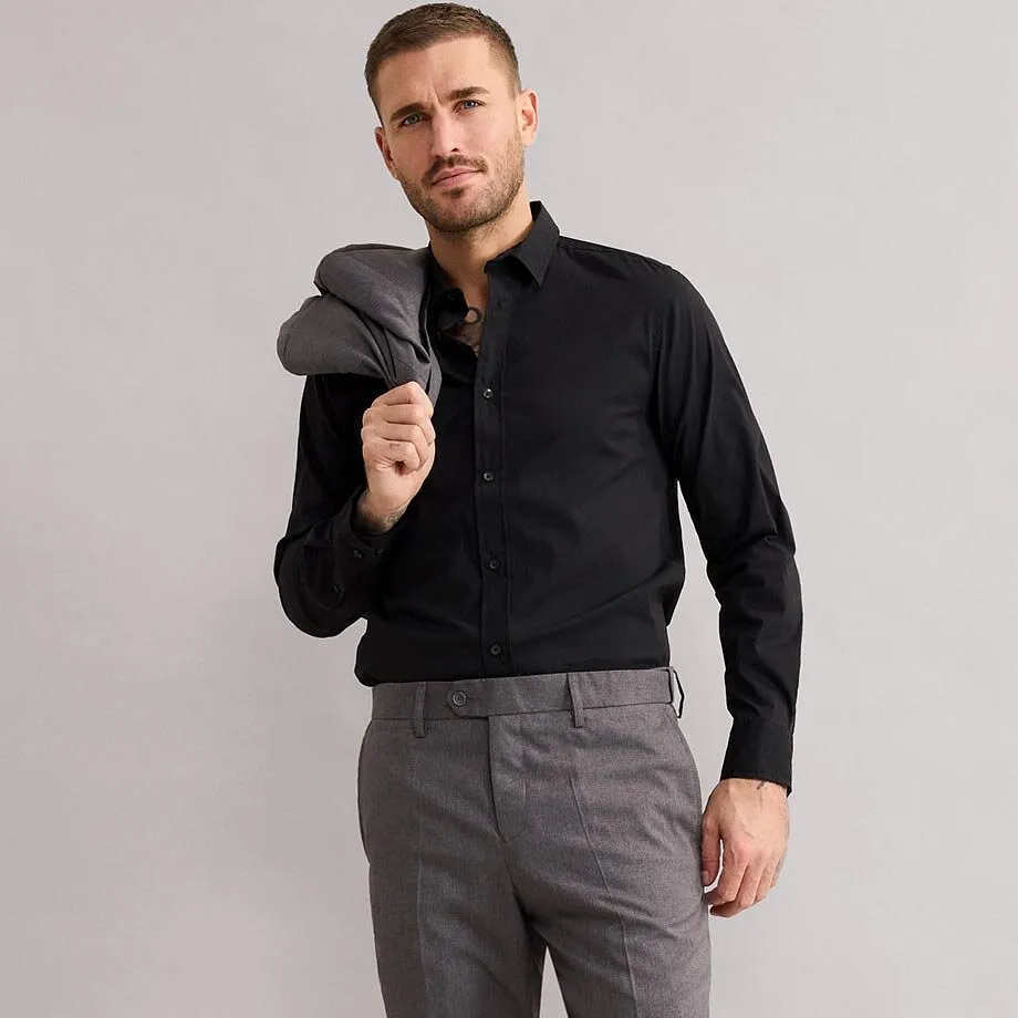 Elegante camicia nera e pantaloni grigi di tessuto. 