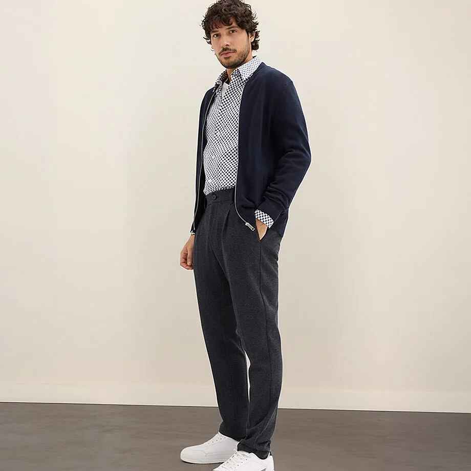Cardigan blu navy, camicia fantasia e pantaloni grigi.